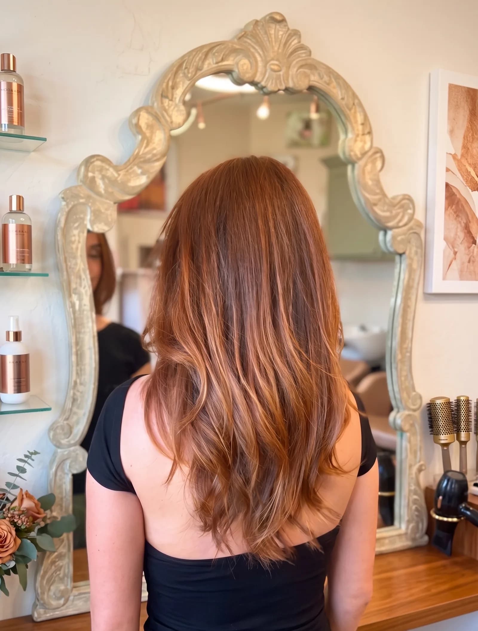 Long auburn blowout with soft waves styled in salon mirror at Salon Lola in Gilbert, Arizona