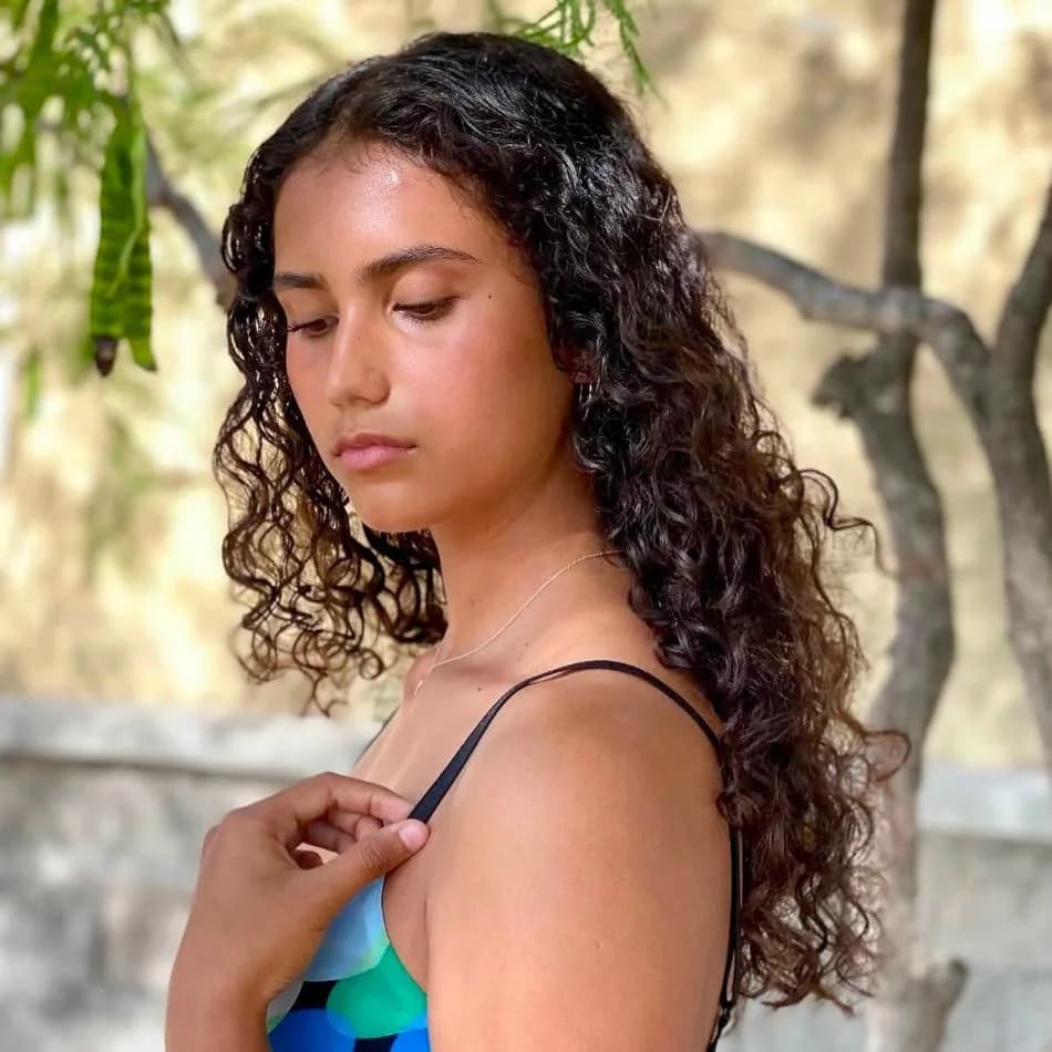 Long natural brunette curls precision cut on client outdoors at Salon Lola in Gilbert, Arizona